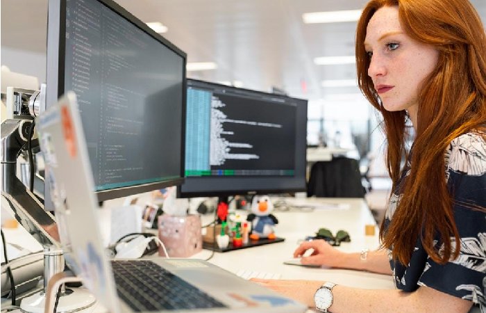 A woman in an office researching optimizing enterprise search performance on her computer