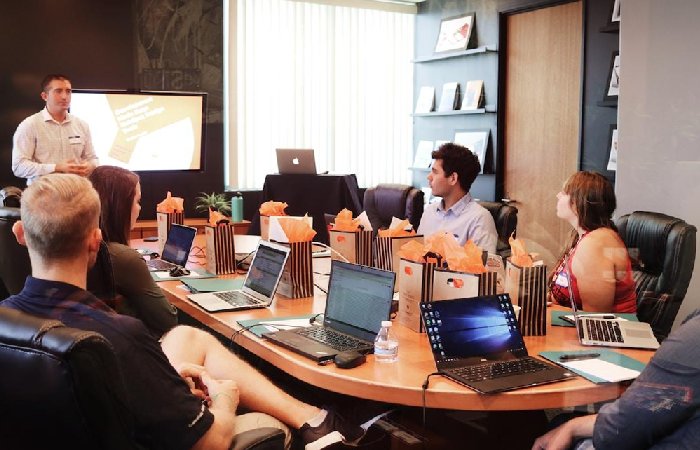 A small team in an office discussing optimizing enterprise search performance during a meeting